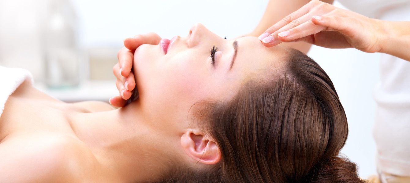 Hands massaging female face at the spa